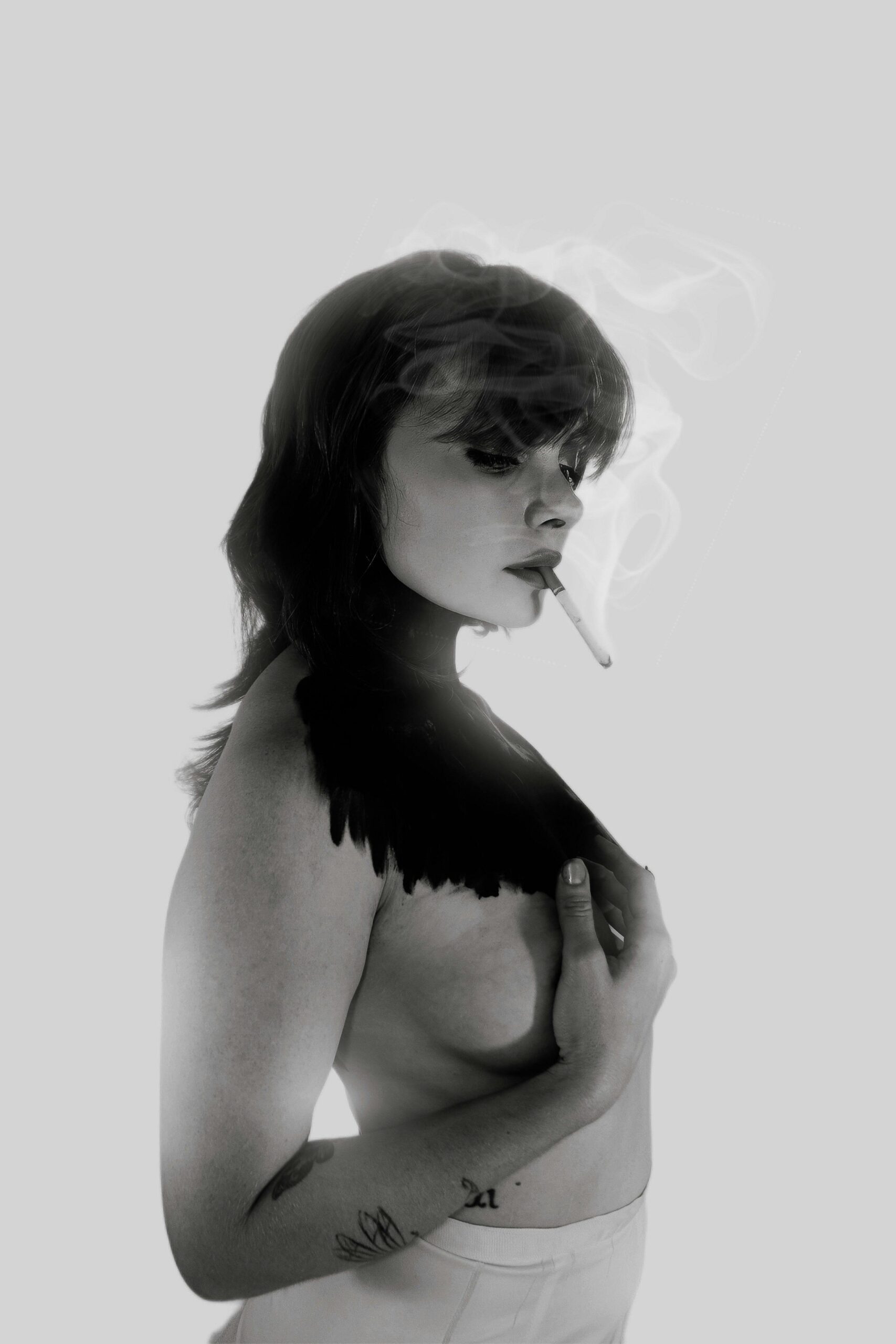 An evocative black and white portrait featuring a woman smoking, conveying mystery.